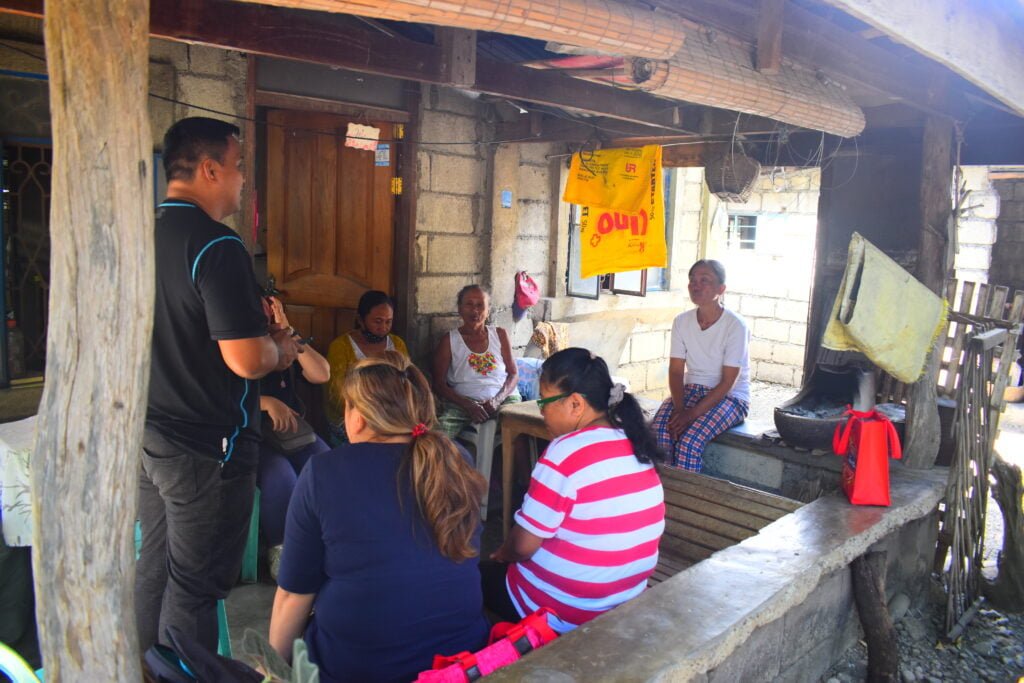 A local church worker listening to women during a community home visit
